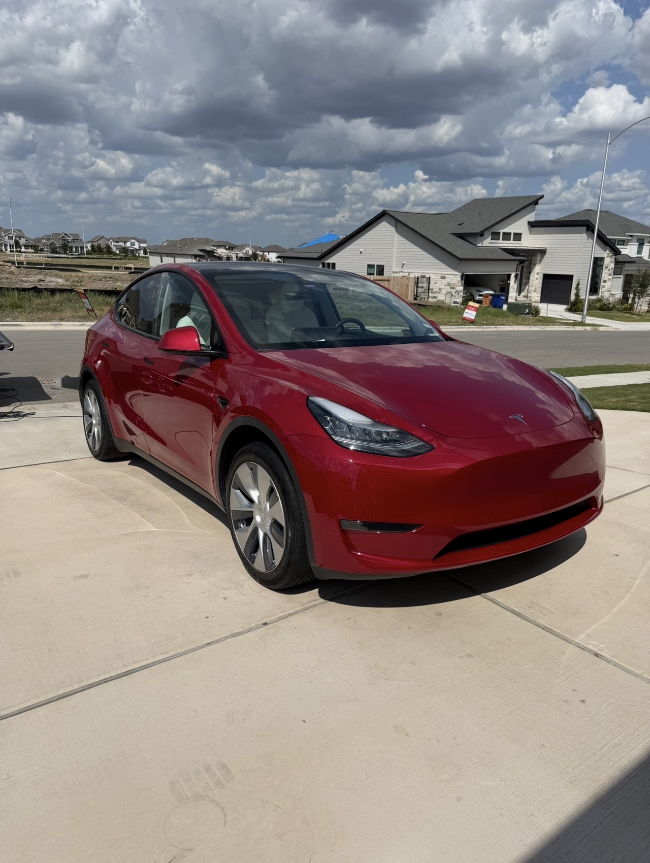 Red Tesla Model Y freshly detailed in a driveway